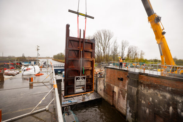 Historische sluisdeur die worden terug geplaatsts in een gerenoveerde sluis